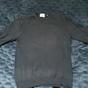 Mörkblå bomullströja från Mq - En stilren svart tröja från Mq i mjuk bomull. Klassisk rund halsringning och ribbade muddar vid ärmslut och nederkant. Perfekt för en enkel och clean look.