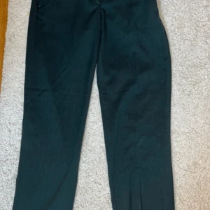 Mörkgröna kostymbyxor från H&M - Mörkgröna kostymbyxor från H&M med raka ben och diskreta fickor bak. Byxorna har normal passform och är tillverkade i en blandning av polyester, viskos och elastan för en bekväm känsla💗💗
