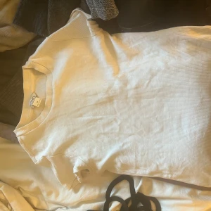 Vit ribbad t-shirt från Monki - Säljer en enkel och stilren vit ribbad t-shirt från Monki i storlek XS. T-shirten har korta ärmar och rund halsringning. Perfekt basplagg till garderoben!