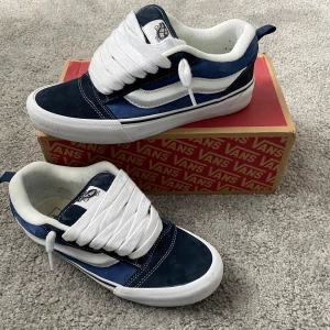 Vans Knu Skool - Säljer ett par klassiska Vans sneakers i blått och vitt med vit sula och snörning. Skorna är inprinsip nya. De har den ikoniska sidoremsan och en tå i mocka. Perfekta för dig som gillar streetstyle och skate.