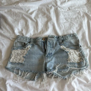 Ljusblå slitna jeansshorts från Levis - Skit snygga low waist jeans shorts som är helt nya 