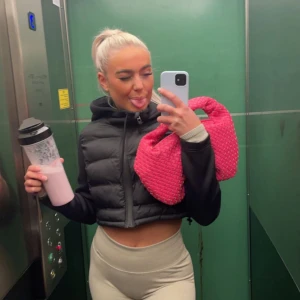 Svart croppad dunjacka - Säljer en svart croppad dunjacka med hög krage och dragkedja framtill. Perfekt att slänga över en hoodie eller långärmad tröja för en sportig look.