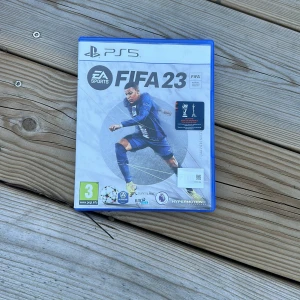 FIFA 23 för PS5 - Säljer FIFA 23 till PS5. Spelet erbjuder realistisk fotbollsaction med uppdaterade lag och spelare. Perfekt för fotbollsfans som vill uppleva spänningen på planen direkt från soffan. Inkluderar HyperMotion2-teknologi för förbättrad spelupplevelse. Kompatibel med PS5.