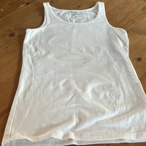 Vit linnetopp från Basic you - Säljer en klassisk vit linnetopp från Gina Tricot. Perfekt för varma dagar eller som lager under andra plagg. Enkel och stilren design med rund halsringning.