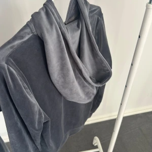 Grå hoodie med dragkedja - Säljer en stilren grå hoodie med dragkedja och huva. Tröjan har långa ärmar och en praktisk ficka framtill. Perfekt för en avslappnad look.