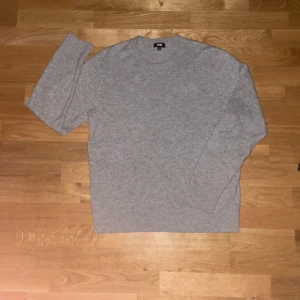 Grå tröja från Uniqlo - Säljer en stilren grå tröja från Uniqlo. Tröjan har en klassisk design med rund hals och långa ärmar. Perfekt för en minimalistisk look.