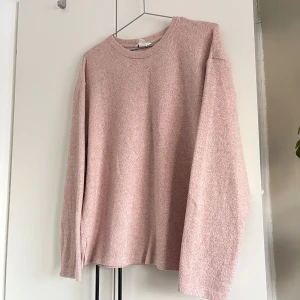 Rosa långärmad tröja - En mysig och mjuk rosa tröja med rund hals, perfekt på vinterns och kalla sommarkvällar. Materialet känns mjukt och bekvämt mot huden.