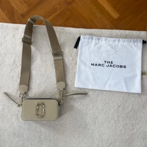 Marc Jacobs snapshot bag - Snapshot väskan från Marc Jacobs i färgen khaki. Använd fåtal gången så i mycket fint skick. Avtagbart axelband om man skulle vilja sätta på ett tunt också. Nypris ca 4500kr