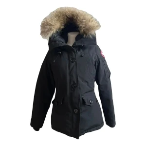 Canada goose Montebello caban - Snygg svart parkajacka från Canada Goose med avtagbar huva och pälsdetalj. Jackan har långa ärmar och flera praktiska fickor med knappar. Perfekt för kalla dagar.