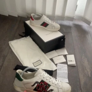 Gucci ace snake skor! (KVITTO, BOX, DUSTBAGS) - Riktigt snygga Gucci Ace Snake skor! Dessa skor är väldigt efterfrågade och få på marknaden. Jag kommer att sälja dessa skor för endast 2399kr, priset är ej hugget i sten (går att ändra). Jag köpte dessa skor i Paris och har kvitto, box, dustbags, kuvert med! Storleken är 42. Skicket på dessa skor är 7/10, de är lite smutsiga men går att tvätta enkelt. Jag kan sänka priset vid snabb affär, skriv om ni har några frågor eller funderingar! Mvh
