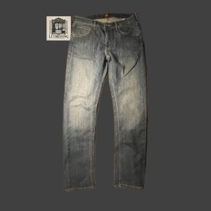 Blå jeans från Lee - 👖Snygga blå jeans från Lee med klassisk femficksdesign och knappgylf. De har en lätt tvättad look och är perfekta för en avslappnad stil. Märkeslogga på baksidan av midjan ger en extra touch. Inga defekter. Nypris 1049kr👖