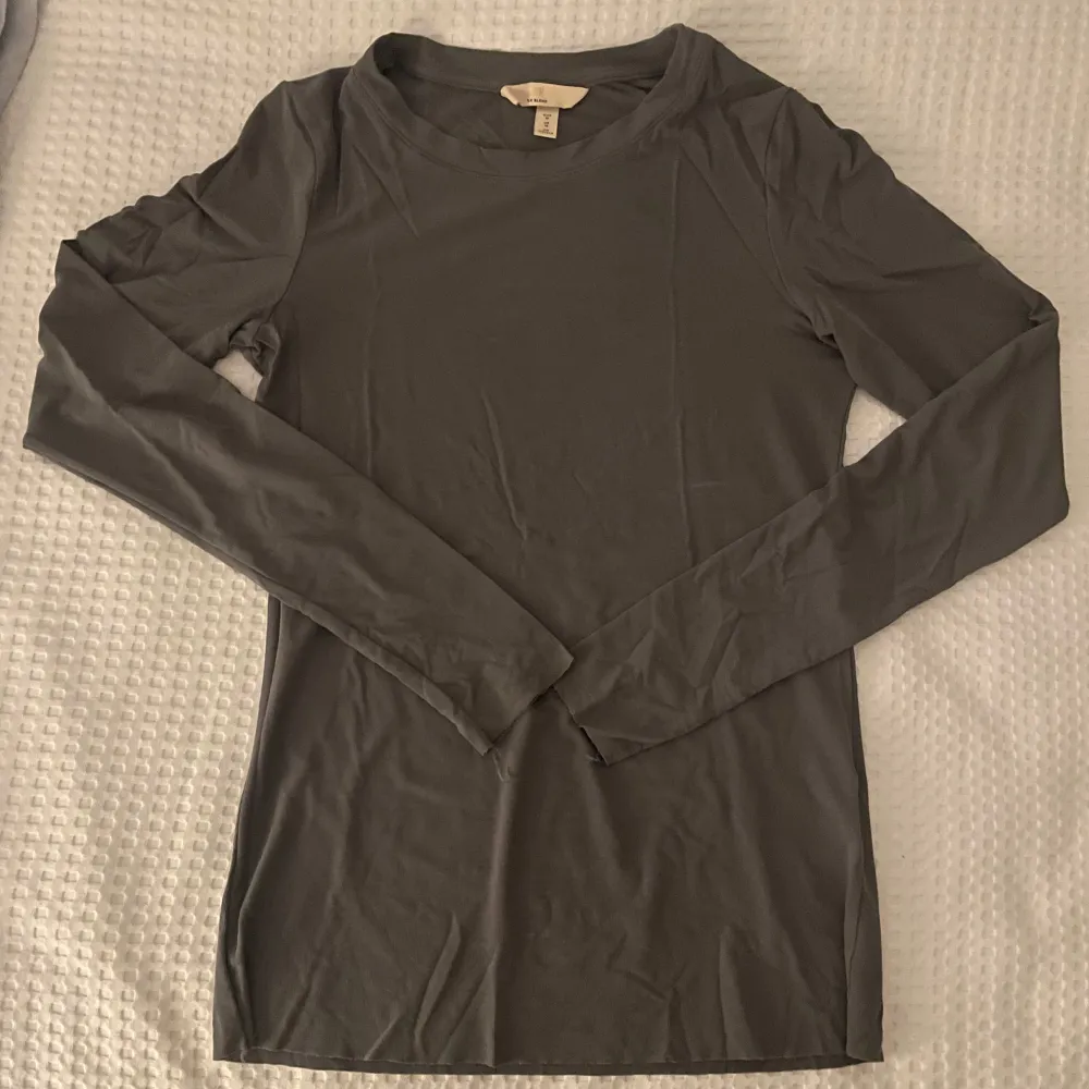 Säljer en stilren grå långärmad topp i mjukt material. Perfekt för lager-på-lager eller som den är. Enkel och mångsidig design som passar till det mesta. Hör av dig vid intresse!. Neuletakit & Villapaidat.