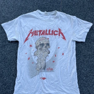 Vit Metallica t-shirt - Säljer en vit Metallica t-shirt med tryck bak och fram. 100% bomull och i storlek M. Välanvänd men inga defekter förutom lite urtvättad känsla 