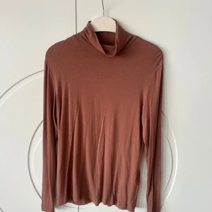 Mörk rosa långärmad polotröja från H&M - Säljer en stilren mörk rosa långärmad polotröja från H&M Basics. Tröjan är tillverkad i ett mjukt och bekvämt material, perfekt för kyligare dagar. Den har en klassisk design med en hög krage som ger extra värme och stil. lite nopprig 