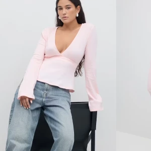 Ljusrosa tie topp  - Säljer en ljusrosa omlottopp från Gina tricot med långa ärmar och v-ringning. Toppen har en knytning i midjan. Perfekt för en stilren look. Använd flera gånger men fortfarande mycket bra skick😊köpt för 299 men säljs för 180kr