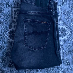 Grim Tim från Nudie Jeans - Nudie jeans grå/svart. I färgen dark days. Modellen är grim Tim vilket ör nudie jeans mest populära modell. Skicket är som nytt. Hör av dig vid frågor!