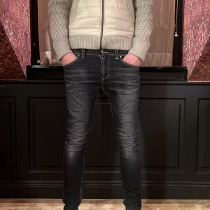 Svarta jeans från Dondup - Snygga svarta jeans från Dondup med en tight passform. De har en klassisk femficksdesign och kontrasterande sömmar. Perfekta för en stilren look. Änvänt endast en gång 