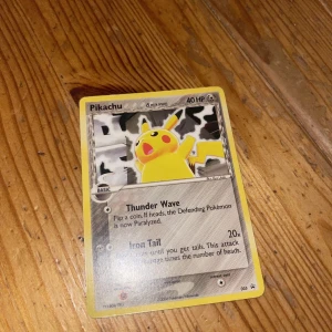 Pikachu Pokémonkort - Säljer ett klassiskt Pikachu Pokémonkort med 40 HP. Kortet har attacker som Thunder Wave och Iron Tail. Perfekt för samlare eller Pokémon-entusiaster!