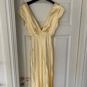Gul långklänning - Helt ny med prislapp! Säljer då den inte passa mig. Superfin gul klänning från Selfie Leslie i satin och öppning i rygg, perfekt till bal💛💛