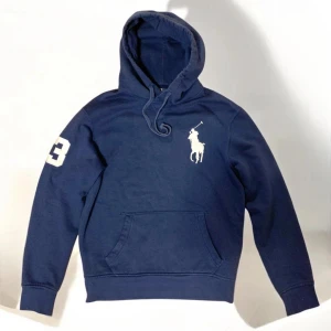 Ralph Lauren Blå Hoodie - Säljer nu denna sällsynta och eftertraktade Hoodie från Ralph Lauren som inte längre går att få tag på. Bra skick utan defekter. Storlek S, Normal i storlek och sitter bra på mig som är 176. Lycka till att hitta denna tröja för ett bättre pris!😉