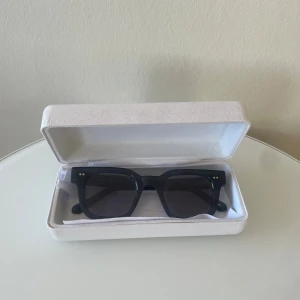 Chimi 04 Dark Grey - Snygga svarta solglasögon med fyrkantig form och mörka linser. Perfekta för en stilren look. Kommer i ett praktiskt fodral. (Näst intill aldrig använda)