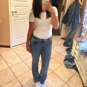 Blå bootcut jeans med fickdetaljer - Snygga blå jeans med bootcut passform och klassiska fickor med knappdetalj bak. Lågmidjade💕 