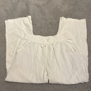 Vita linnebyxor storlek 150 - Säljer ett par vita linnebyxor storlek 150 med elastisk midja och snörning. Från lager 157. Byxorna har raka ben, sidofickor och en bakficka. Perfekta för en chill och avslappnad stil. Nyskick 