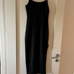 Svart klänning med slits från SHEIN  - En svart klänning från SHEIN i storlek XS Petite så skulle sägs xss/xs. Klänningen har smala axelband och en slits nertil. Perfekt för dig som gillar minimalistisk stil och vill ha en enkel men snygg look. Använd 2 gånger 