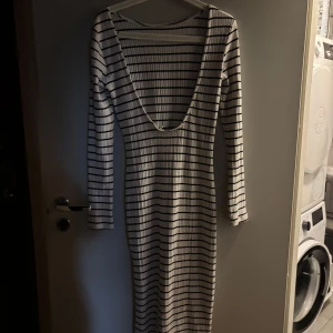 Randig långklänning med öppen rygg - Klänning från NAKD som aldrig blivit använd i storlek 38. 