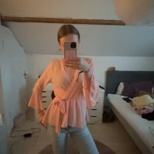 Ljusrosa omlottblus från Boohoo - Superfin ljusrosa omlottblus från Boohoo med knyt i midjan och vida trekvartsärmar. Köpt på Sellpy men passade inte riktigt.