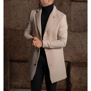 Beige rock från IC med klassisk look - Snygg beige rock från IC med klassisk krage och knäppning framtill. Jackan har raka linjer, två fickor med lock och är tillverkad i ett mjukt ullmaterial. Perfekt för dig som vill ha en stilren och tidlös vibe till höst och vinter.