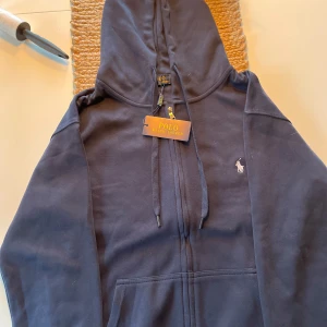 Marinblå hoodie från Polo Ralph Lauren - Snygg marinblå hoodie från Polo Ralph Lauren helt ny inte använd en gång pågrund att den var för liten när jag fick den