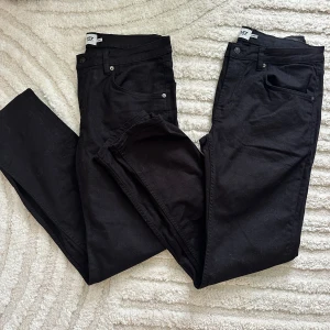 Svarta jeansbyxor från 157, W36 L34 - Svarta jeansbyxor från 157 med klassisk femficksdesign och raka ben. Byxorna är tillverkade i bomull och har en stilren look som passar till det mesta. Midjan är normal och passformen är rak, vilket ger en clean och enkel vibe.