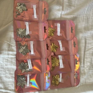 Guldigt o silvrigt halsband med blomma - SKRIV PRIVAT FÖR KÖP!! Snyggt halsband med en stor, detaljerad blomma i guldton o silverton. Kedjan är tunn och elegant, och blomman har fina räfflade blad som ger ett lyxigt intryck. Perfekt accessoar för att lyfta din outfit med en trendig touch.