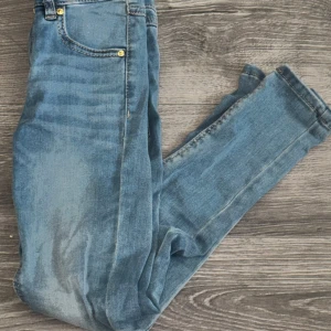 Jeans från LAB Industries, kids 134 - Snygga ljusblå jeans från LAB Industries i stretchigt material. Klassisk femficksmodell med gylf och knapp, tillverkade av bomull, polyester och elastan. 