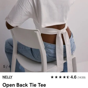 Vit knyttopp nelly - Säljer en vit croppad topp från Nelly med öppen rygg och breda knytband bak. T-shirten har korta ärmar och en tight passform som framhäver midjan. Perfekt för dig som vill ha en enkel men ändå unik look. Använd typ två ggr inga tecken på användning❤️