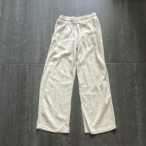 Beiga linnebyxor från Lindex Kids - Snygga och luftiga beiga linnebyxor från Lindex Kids med resår i midjan och raka, vida ben. 