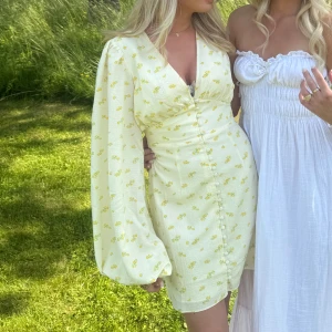 Adoore klänning - Superfin ljusgul kortklänning med små blommor, djup v-ringning och markerad midja. Perfekt för sommarens alla tillfällen !💕🦋