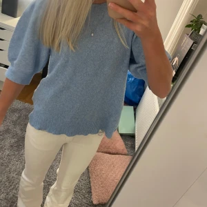 Ljusblå stickad tröja  - Superfin ljusblå stickad tröja med puffiga halvlånga ärmar och ribbade kanter. Tröjan har en avslappnad passform. 