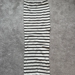 Randig långkjol från Bershka XS - Supersnygg långkjol från Bershka i ribbat material. Kjolen är vit med svarta horisontella ränder och har en tight passform. Perfekt att styla med en croppad topp eller stickad tröja.