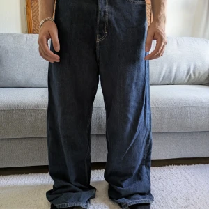 Weekday Astro Loose Baggy Jeans blå - Säljer ett par Weekday Astro Loose Baggy Jeans i mörkblå denim. De har riktigt bred passform, raka ben och klassiska kontrastsömmar. Jeansen är tillverkade i bomull och har stora bakfickor. Perfekta för dig som gillar en avslappnad och trendig stil.