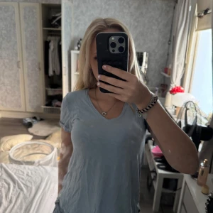 Ljusblå v-ringad t-shirt - En basic ljusblå t-shirt från Nicole Henry med v-ringning och korta ärmar. Skön passform och tillverkad i mjuk bomull, perfekt till jeans eller shorts. Enkel och stilren design som funkar till det mesta.