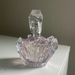 Ariana Grande parfym i kristallflaska - Superfin parfym från Ariana Grande i en unik, kristallformad flaska med lila toner och silvrig spraydel. Flaskan har ett coolt avtagbart kristallställ som ger lyxig känsla och är perfekt som inredningsdetalj på sminkbordet.