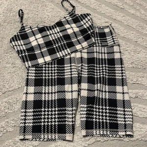 Rutig svartvit linnetopp och cykelbyxor från Aimn - Snygg linnetopp och cykelbyxor från Aimn med svartvitt rutigt mönster och smala axelband. Toppen är croppad och har en cool, sportig vibe som passar perfekt till matchande shorts eller jeans. Mjukt och stretchigt material som sitter skönt på kroppen.