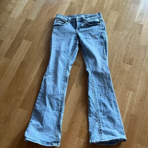 Ljusblå bootcut jeans från Perfect Jeans - Säljer ett par ljusblå jeans från Perfect Jeans med bootcut-passform. Byxorna har klassiska fickor både fram och bak, samt snygga detaljer med knappar på bakfickorna. Perfekta för dig som gillar en lite vidare siluett nertill.