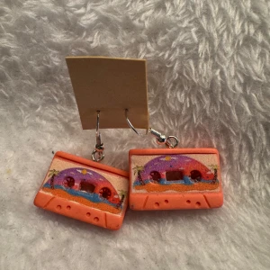 Färgglada kassettbandsörhängen - Unika örhängen formade som retro kassettband i orange med färgglada detaljer och palmer. Perfekt för dig som vill sticka ut med en lekfull accessoar.