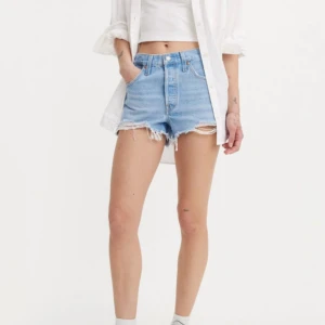Ljusblå jeansshorts från Levi's  - Säljer ett par  ljusblå jeansshorts från Levi's med fransade kanter och femficksmodell. Lappen är borta och är osäker på storlek med tror det är w27! Sitter som s-m