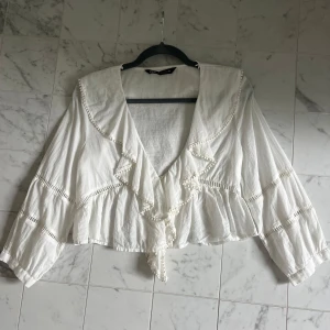 Vit blus med volanger - Säljer den här fina oanvända sommarblusen ifrån Zara då den aldrig kommit till användning. Perfekt nu till våren/sommaren!!