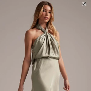 Ljusgrön halterneck bal klänning - Säljer en elegant ljusgrön långklänning med halterneck och draperad överdel. Aldrig använd, den satt dåligt så därför säljer jag vidare.Klänningen har en mjuk, glansig yta och en figurnära passform upptill som faller snyggt längs kroppen. Perfekt för speciella tillfällen. Kostar 1569 urpsrungligen men säljer för 1200