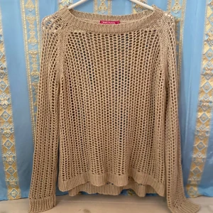 Beige stickad nättröja från Indiska - Säljer en beige stickad nättröja från Indiska. Tröjan har lång ärm och är gjord i ett grovmaskigt stickat material som ger en luftig känsla. Perfekt att styla över ett linne eller topp för en avslappnad look.